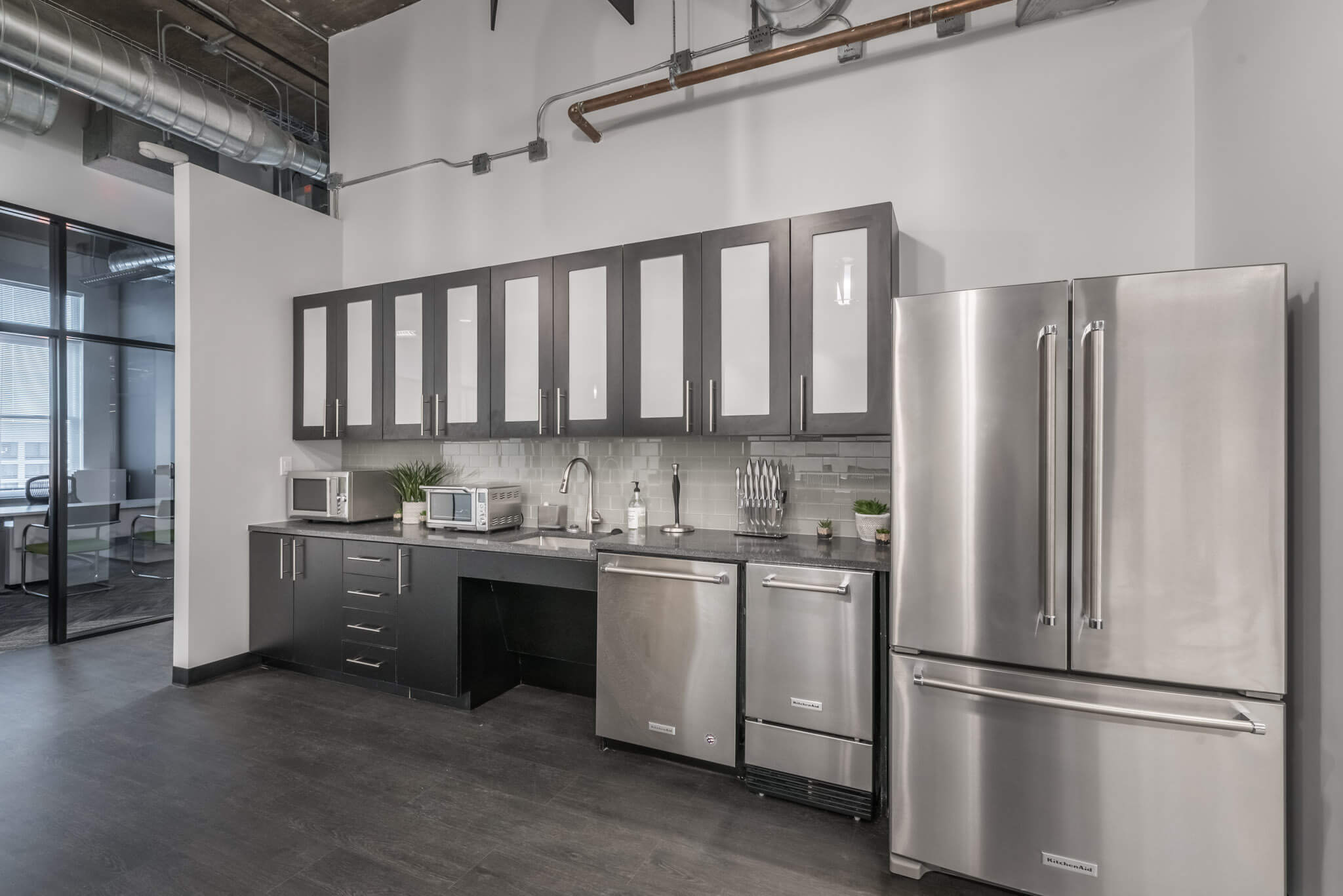 A kitchen with stainless steel appliances and cabinets.