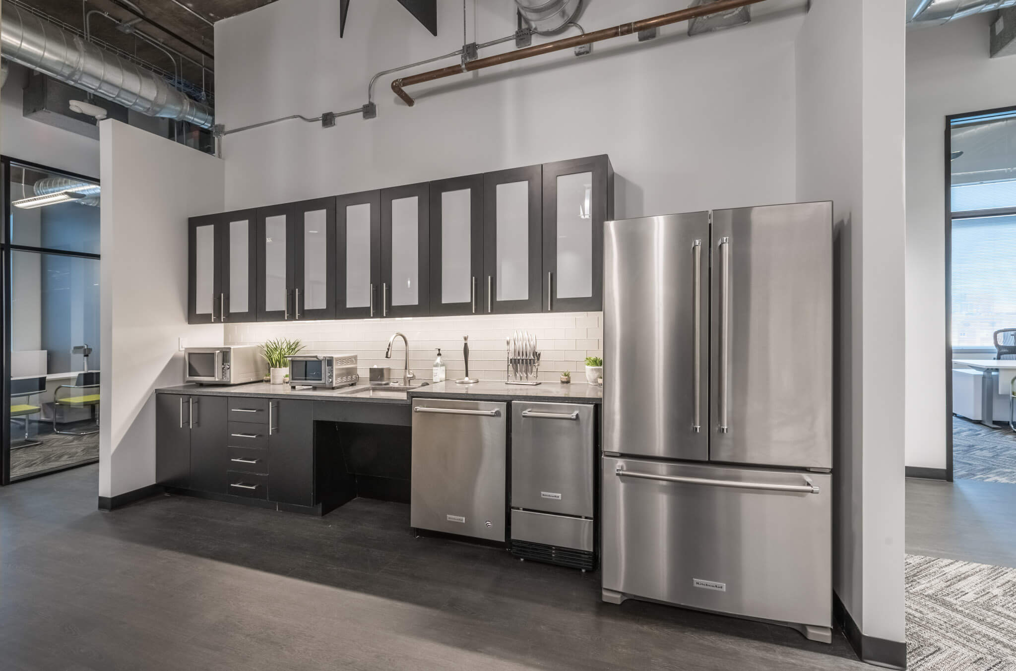 A kitchen with stainless steel appliances and cabinets.