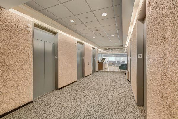 A long hallway with many doors and some floors