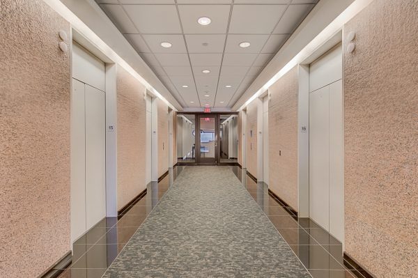 A long hallway with many doors and lights.